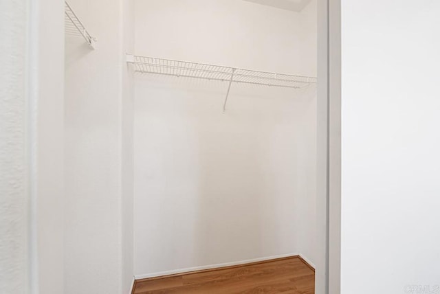 walk in closet with wood finished floors