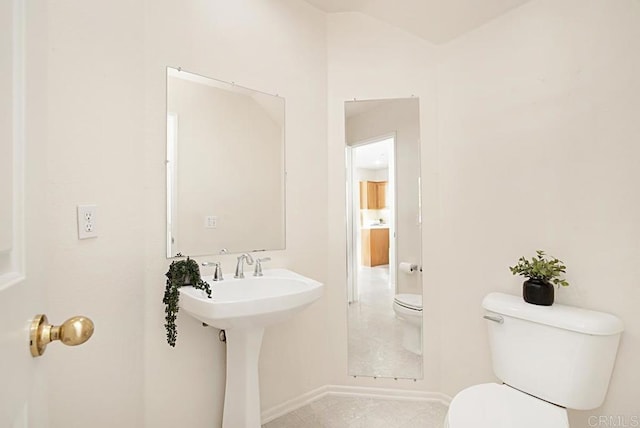 bathroom with tile patterned flooring, toilet, and baseboards