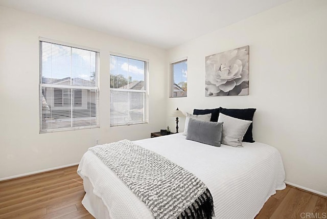 bedroom with baseboards and wood finished floors