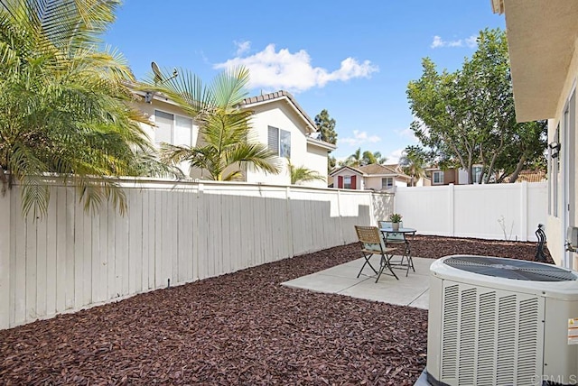 view of yard with a patio, central AC, and a fenced backyard