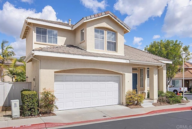 view of front of house featuring fence, driveway, an attached garage, stucco siding, and a tiled roof