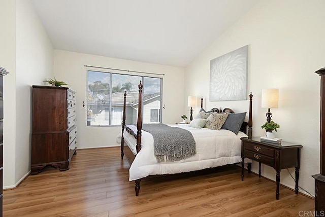 bedroom with vaulted ceiling and light wood finished floors