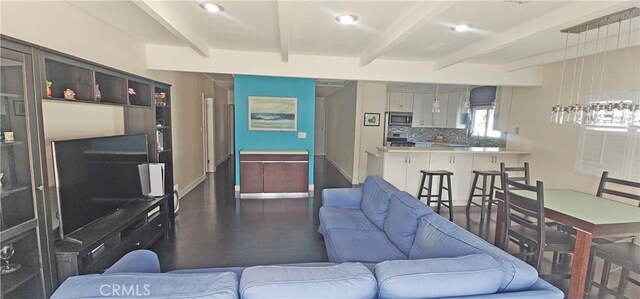 living room with beam ceiling, recessed lighting, baseboards, and wood finished floors