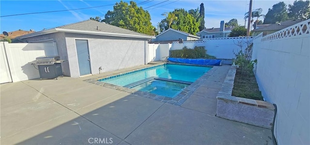 view of pool featuring area for grilling, a fenced backyard, and a patio area