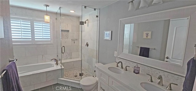 bathroom with a bath, a shower stall, toilet, and a sink