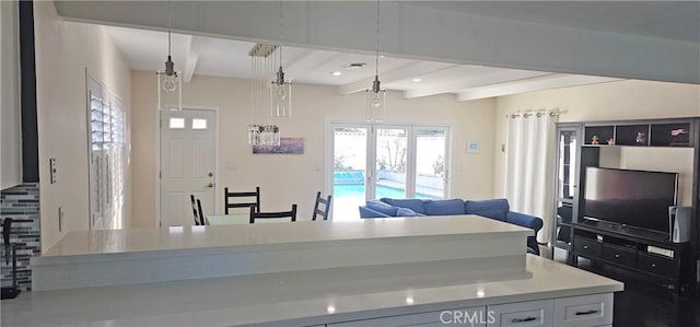 kitchen with visible vents, beam ceiling, pendant lighting, open floor plan, and light countertops