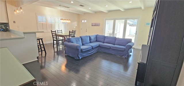 living room featuring visible vents, dark wood finished floors, beamed ceiling, recessed lighting, and a notable chandelier