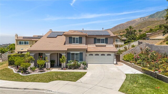 view of front facade featuring driveway, a tile roof, fence, a front yard, and solar panels