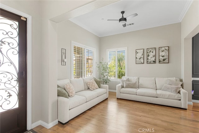 living area with ceiling fan, light wood-type flooring, baseboards, and ornamental molding