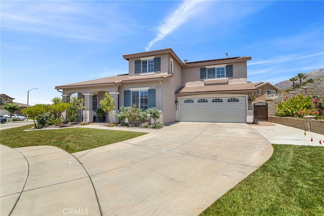 mediterranean / spanish house with stucco siding, driveway, a front lawn, an attached garage, and a tiled roof