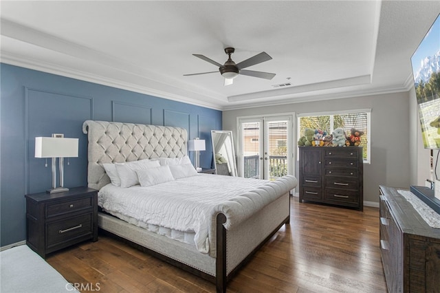 bedroom with visible vents, access to exterior, a tray ceiling, ceiling fan, and dark wood-style flooring