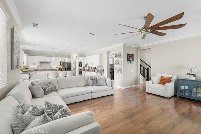 living room featuring visible vents, stairs, dark wood-type flooring, and ornamental molding