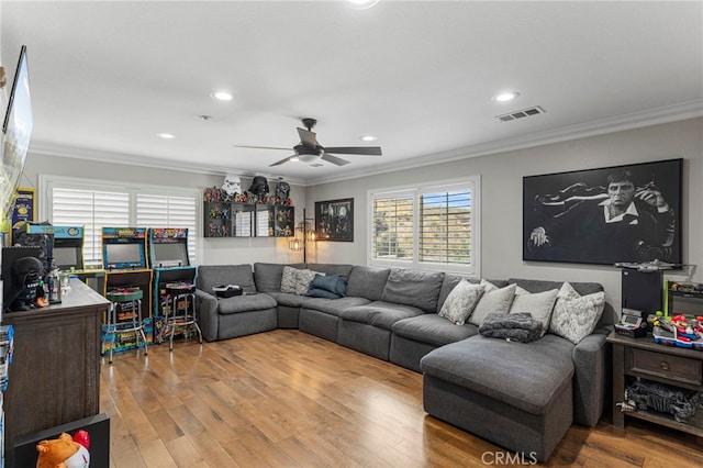 living area with crown molding, recessed lighting, wood finished floors, and visible vents