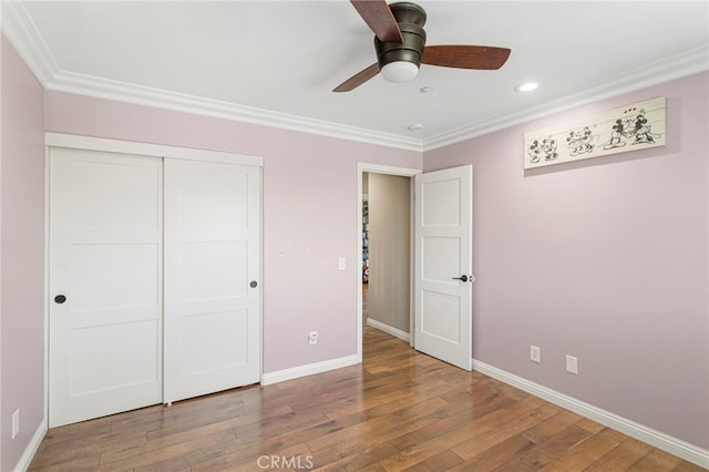 unfurnished bedroom featuring baseboards, hardwood / wood-style floors, and ornamental molding