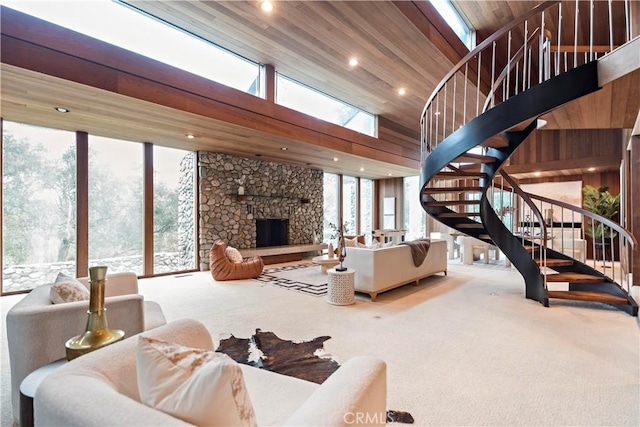 living area with stairs, a healthy amount of sunlight, carpet floors, and a fireplace