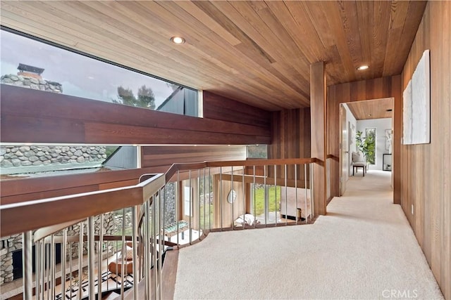 corridor featuring carpet flooring, recessed lighting, wooden ceiling, and wooden walls