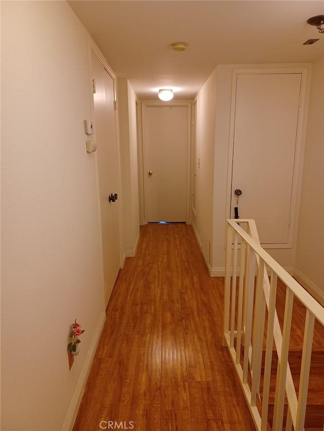 hallway featuring light wood-style floors and baseboards