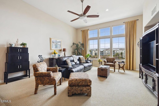 living room featuring visible vents, light carpet, baseboards, and ceiling fan