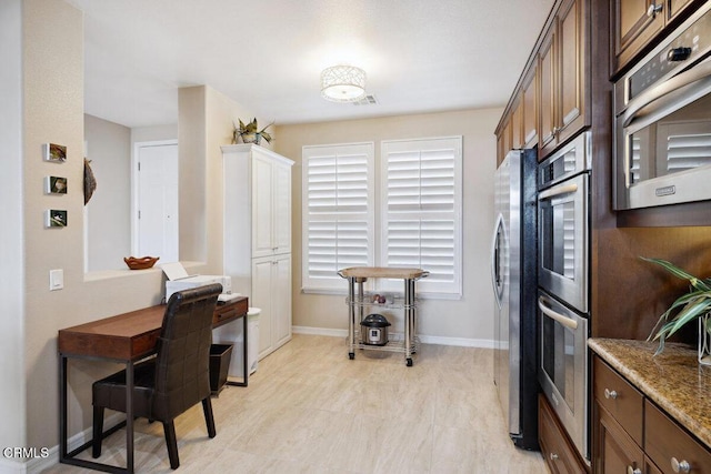 kitchen featuring visible vents, baseboards, appliances with stainless steel finishes, and light stone countertops