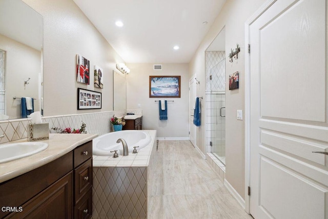 full bathroom with visible vents, a garden tub, two vanities, a sink, and a shower stall