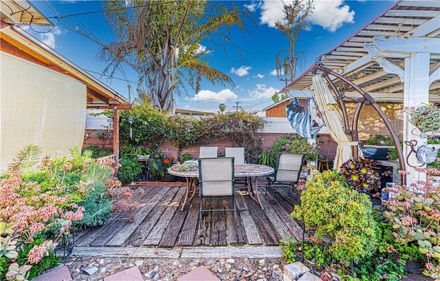 wooden terrace with outdoor dining space and fence