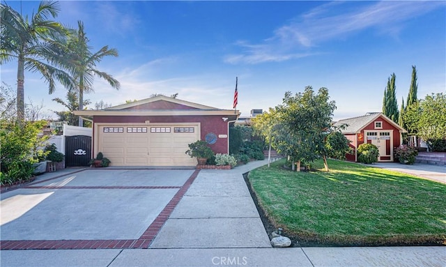 view of front facade with concrete driveway, a front yard, stucco siding, a garage, and a gate