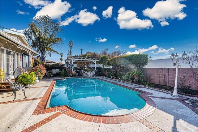 view of swimming pool featuring a patio, a fenced in pool, a fenced backyard, and a pergola