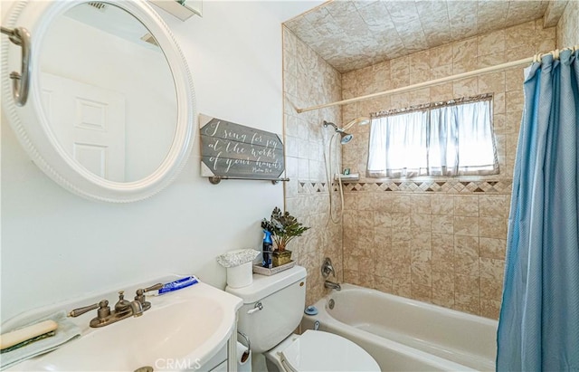 bathroom with a sink, shower / bathtub combination with curtain, and toilet