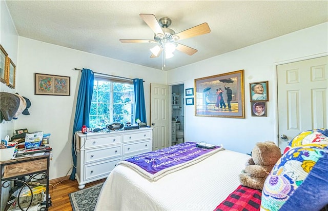 bedroom featuring ceiling fan, a textured ceiling, and wood finished floors