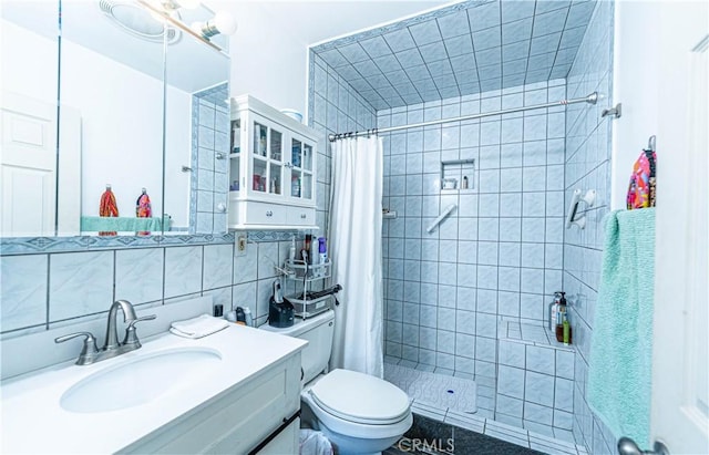 full bathroom featuring a tile shower, toilet, tasteful backsplash, and tile walls