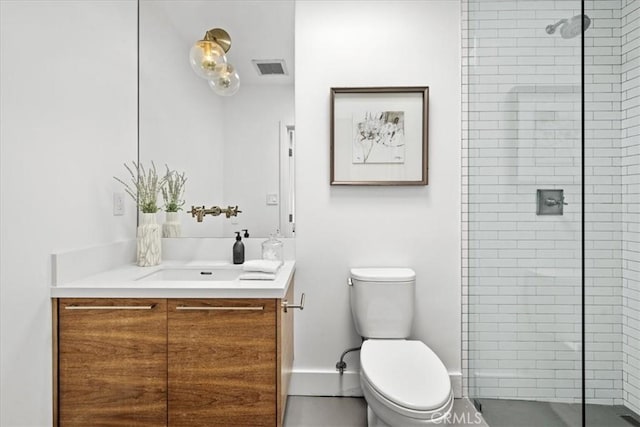 full bathroom featuring a tile shower, toilet, vanity, and baseboards