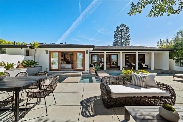 rear view of property with stucco siding, an outdoor pool, outdoor dining area, an outdoor hangout area, and a patio area