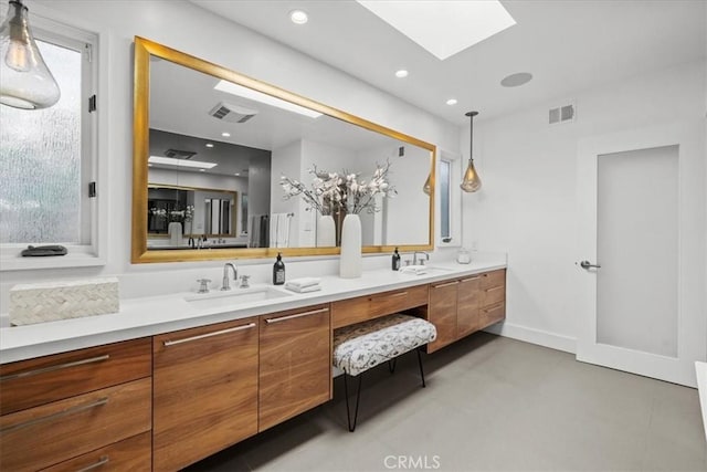 bathroom featuring a sink, visible vents, a skylight, and double vanity