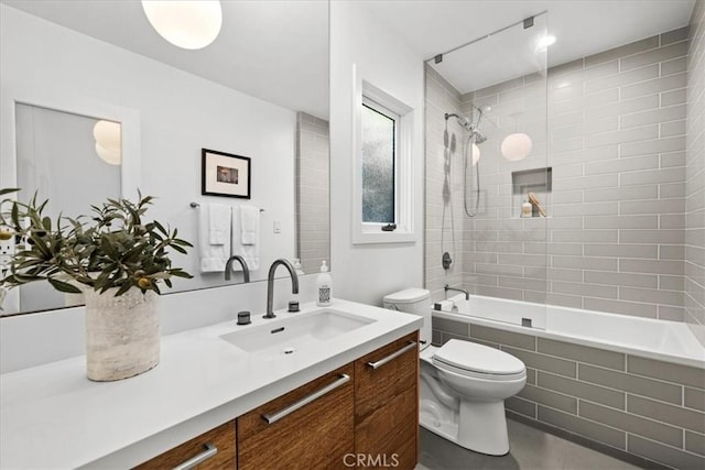 full bathroom featuring tiled shower / bath, toilet, and vanity