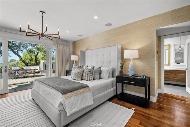 bedroom featuring wood finished floors, baseboards, wallpapered walls, an inviting chandelier, and access to outside