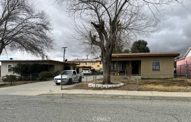 view of front of home with a fenced front yard, stucco siding, and driveway