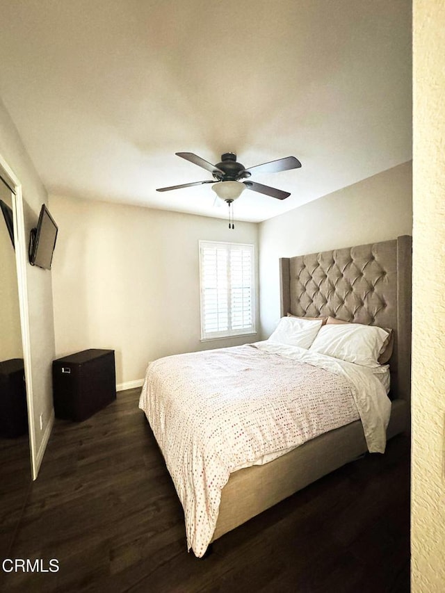 bedroom featuring ceiling fan, baseboards, and dark wood-style floors