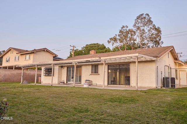 back of house featuring a patio area, a lawn, and fence