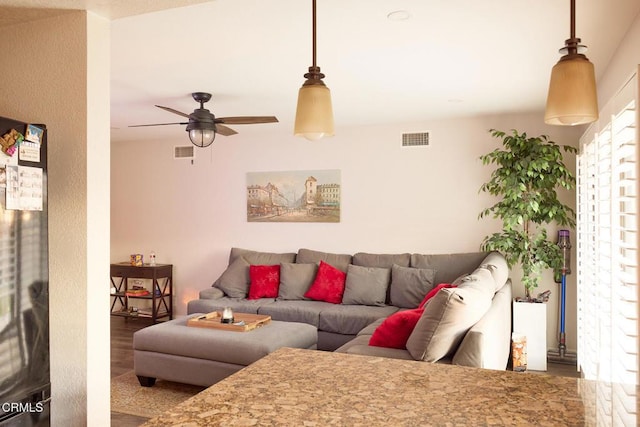 living area with visible vents and ceiling fan