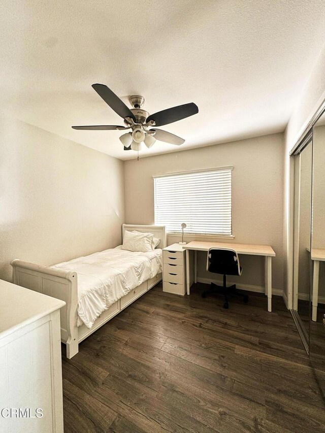 bedroom with a ceiling fan, dark wood-style flooring, a closet, and a textured ceiling