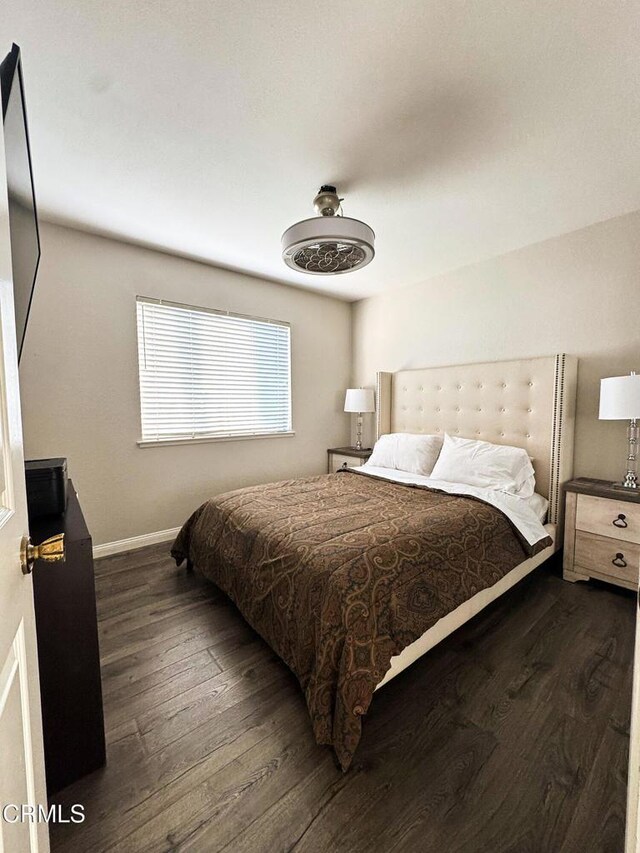 bedroom with dark wood-style floors and baseboards