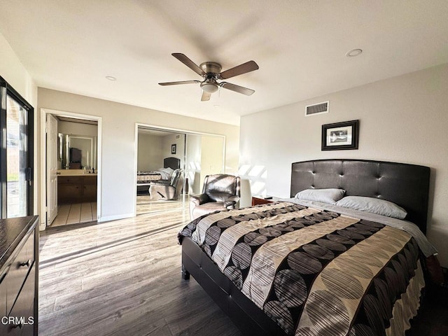 bedroom featuring wood finished floors, visible vents, ceiling fan, a closet, and connected bathroom