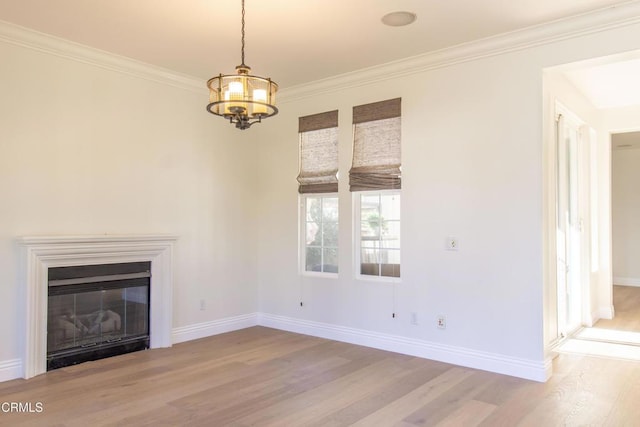 unfurnished living room with a glass covered fireplace, crown molding, wood finished floors, and baseboards