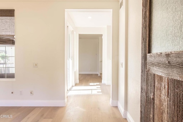 corridor featuring visible vents, baseboards, and wood finished floors