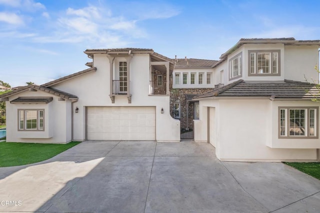 view of front of home with a tile roof, stucco siding, concrete driveway, and a garage