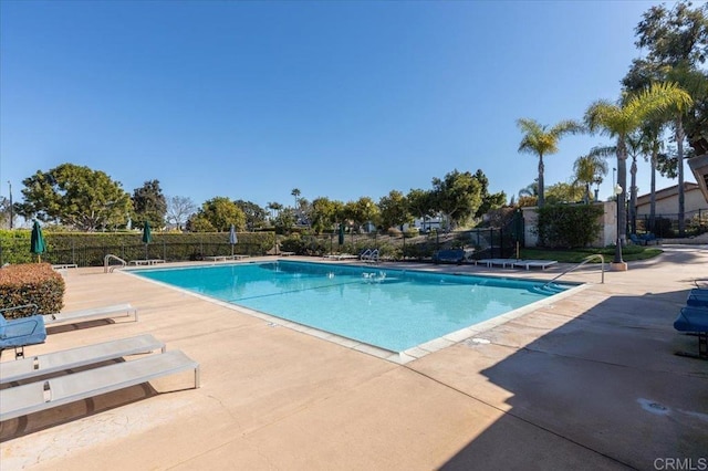 community pool featuring a patio area and fence