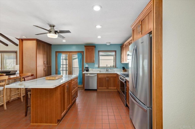 kitchen featuring a sink, stainless steel appliances, light countertops, french doors, and tile patterned floors