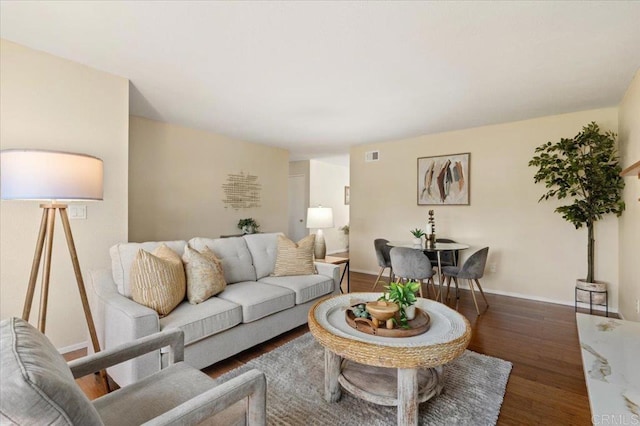 living area featuring visible vents, wood finished floors, and baseboards