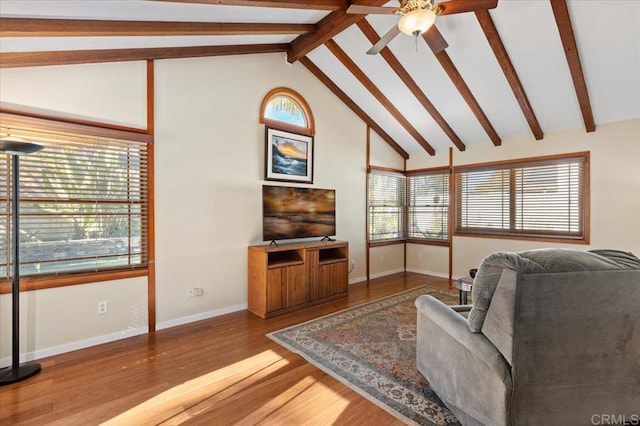 living room with ceiling fan, baseboards, beam ceiling, wood finished floors, and high vaulted ceiling