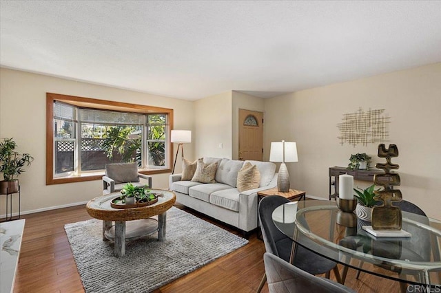 living area with baseboards and wood finished floors